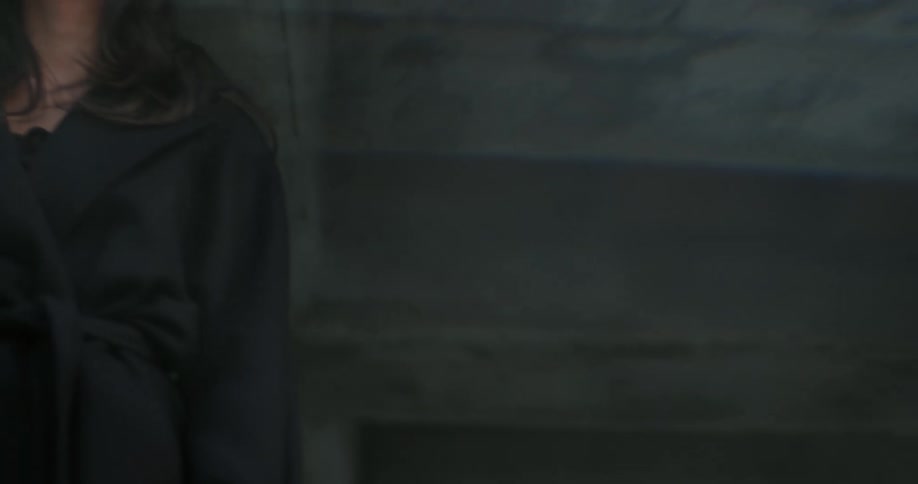 Women wearing black coat and blazer jacket look up on top of the building