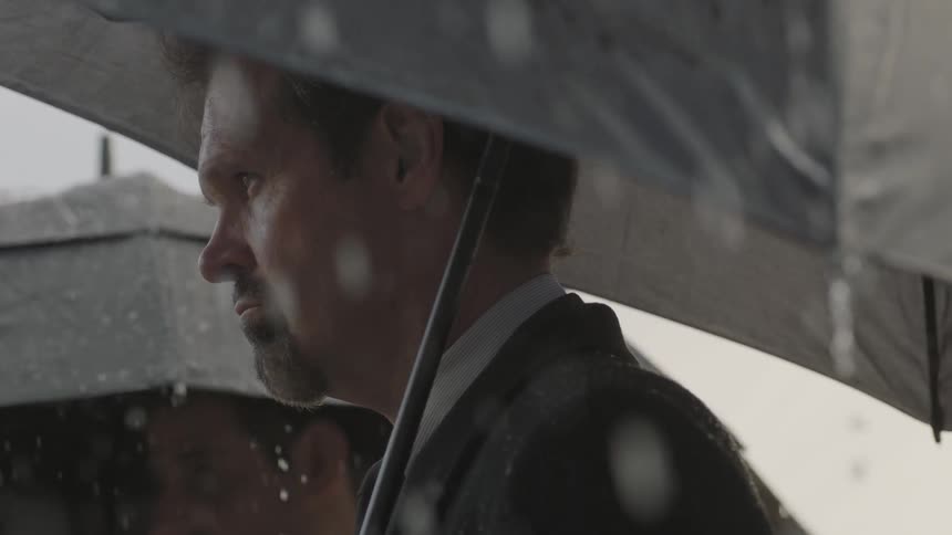 Rain falls around man with an umbrella
