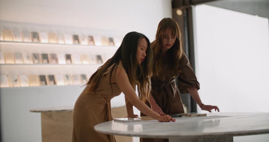 Two women talking and pointing at papers on a table