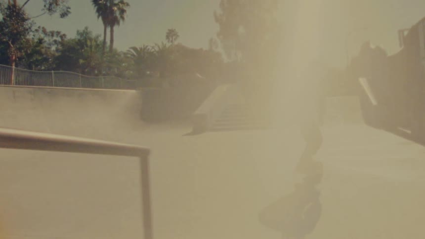 A man skateboarding around a skate park on a bright sunny day
