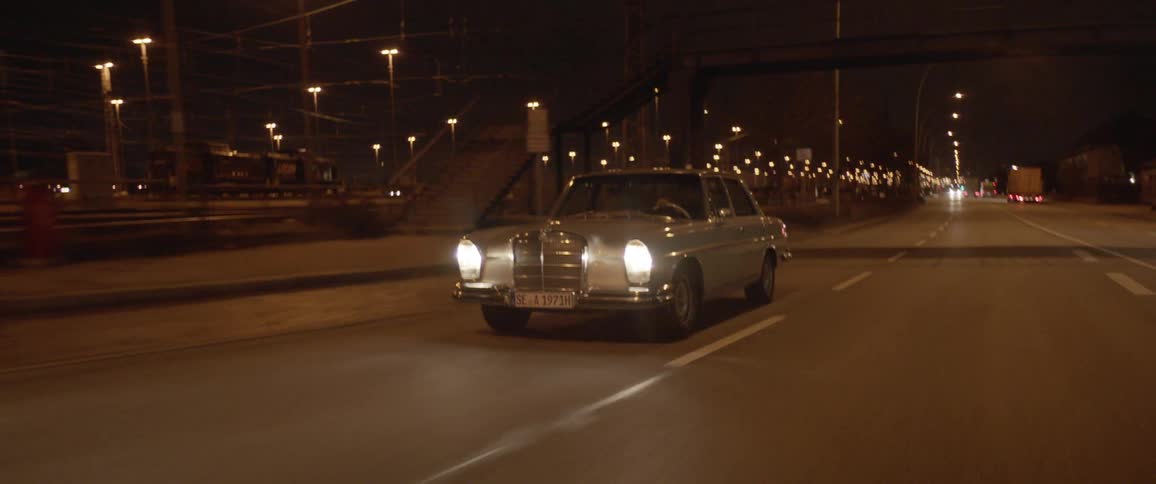 A car is driving on a road during the night time