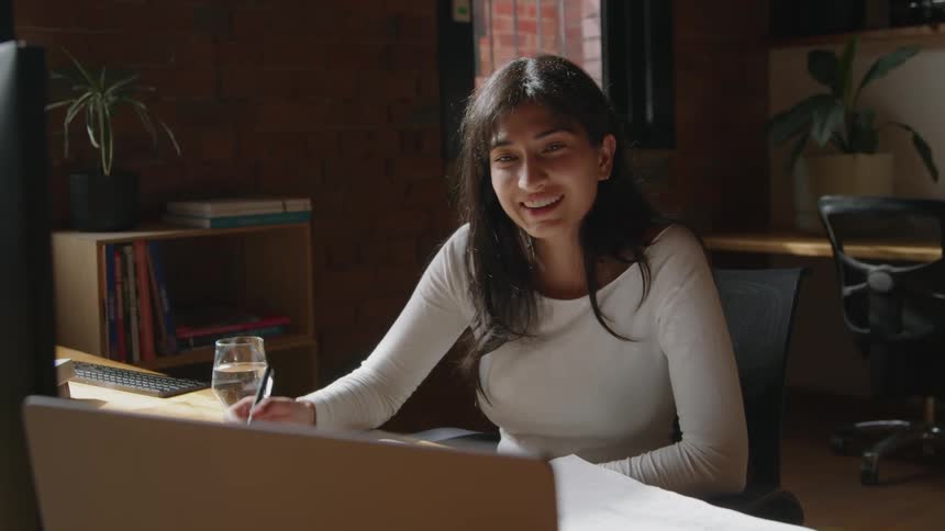 A young woman is working in the office in the middle of the day time