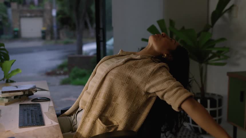 A woman laughs at her computer