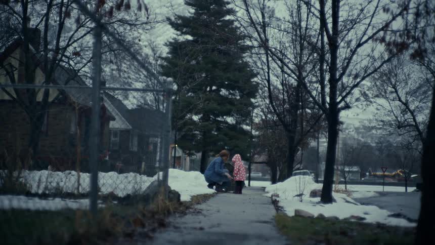 A mother zips up her childs coat