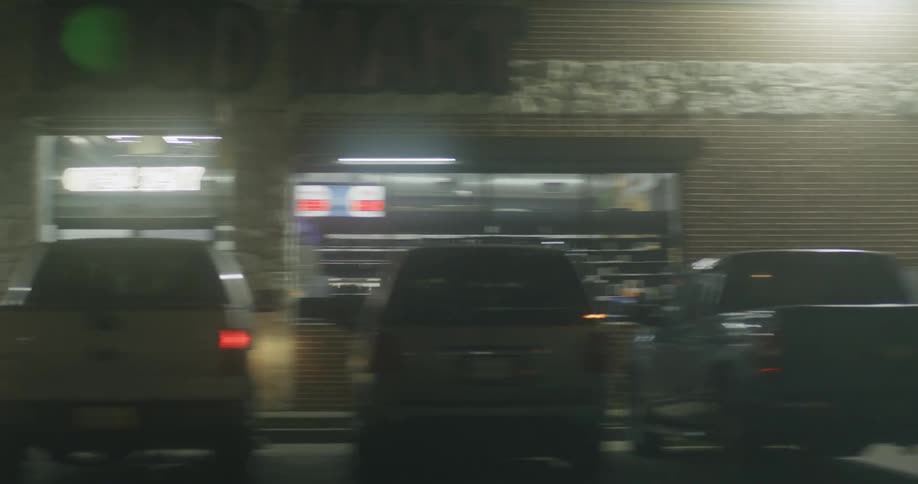 Cars are driving through a city during the night