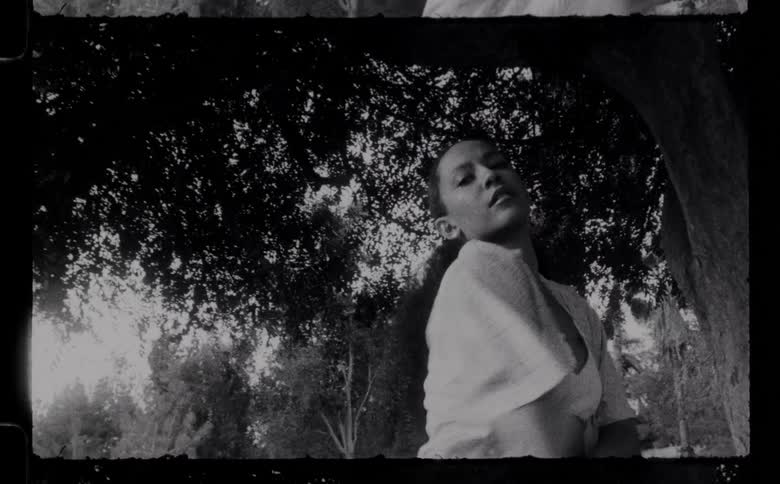 A woman dancing underneath a tree