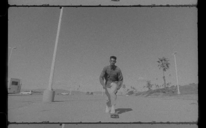 Black and white video of a black male skateboarding