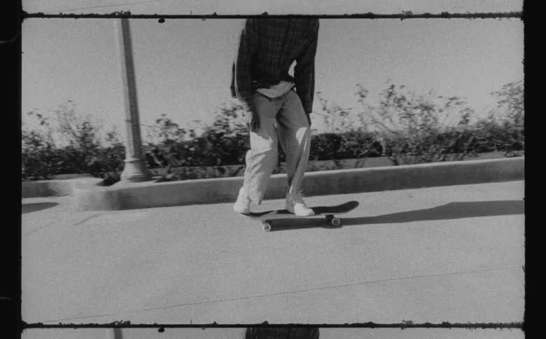 A man does a jump trick while riding his skateboard