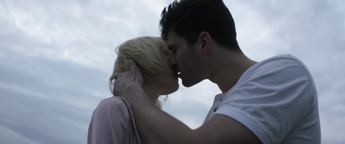 A couple are kissing outside