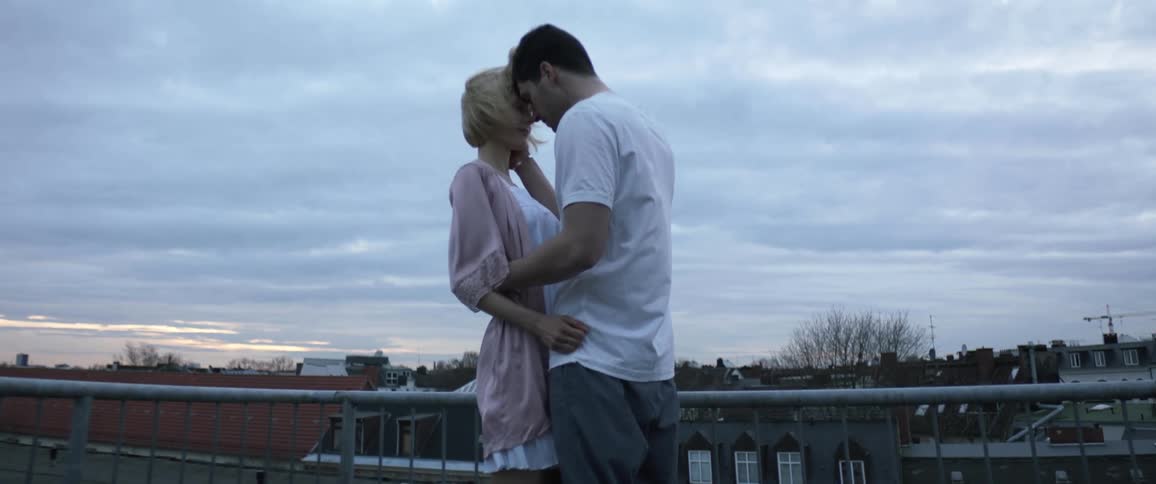 A young couple is making out outdoors in the day time
