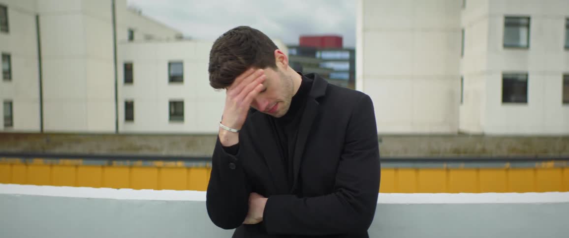 A man is modeling outdoors by the building