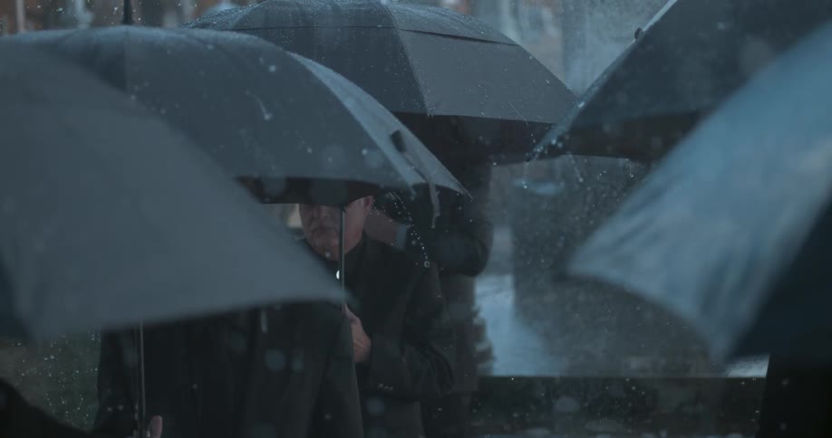 Rail falls on the umbrellas people are carrying