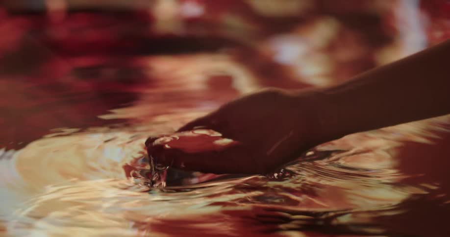 A person dipping their hands in and out of a water