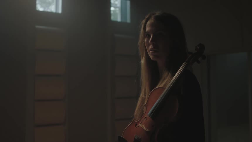 A woman is holding a violin