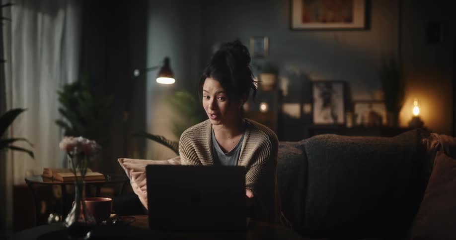 A woman is talking to someone with her laptop