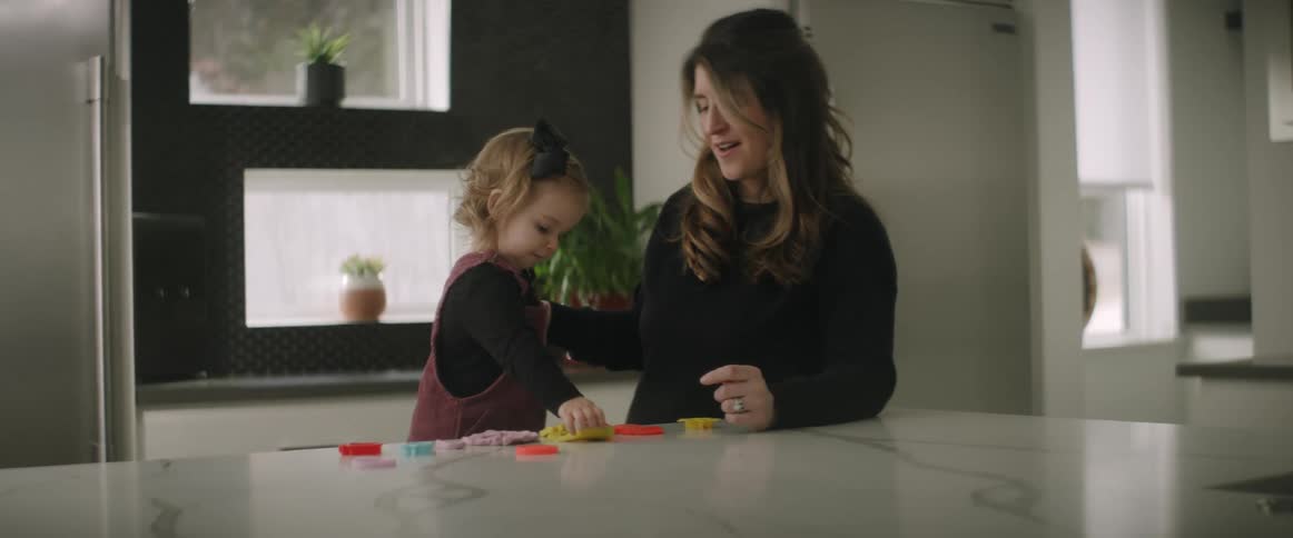 A mother and daughter play with blocks