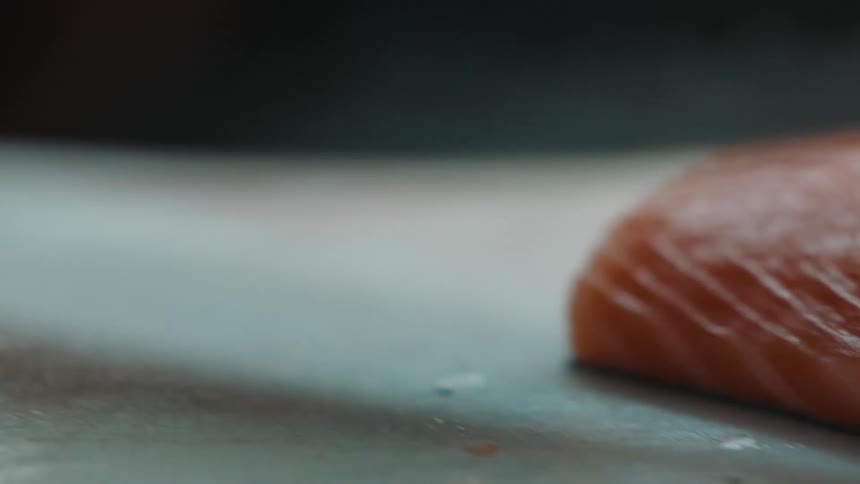 Person uses knife to cut fish steak