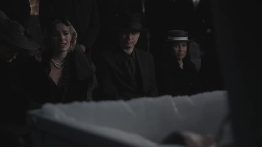 A woman sobs at a funeral as the casket is opened