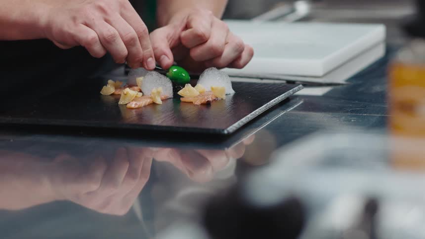 A chef is plating a meal