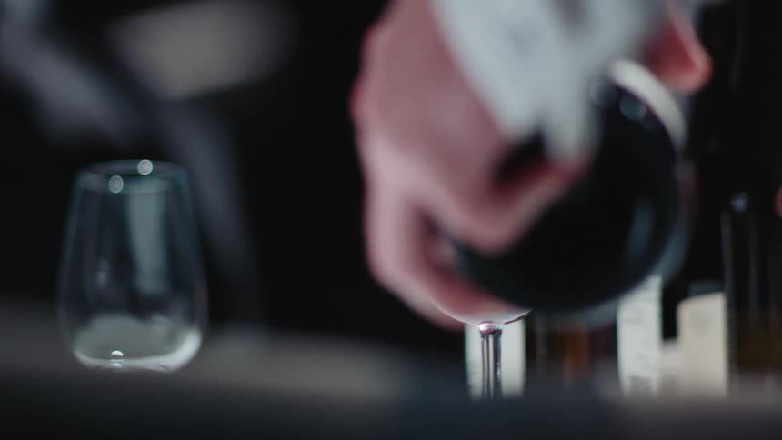 A person pouring wine into a wine glass