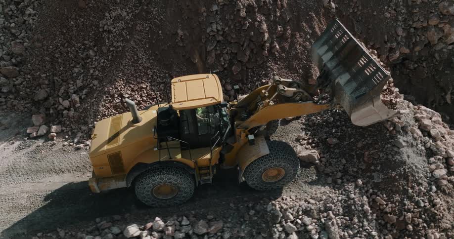 A cat bulldozer carrying and dropping rocks