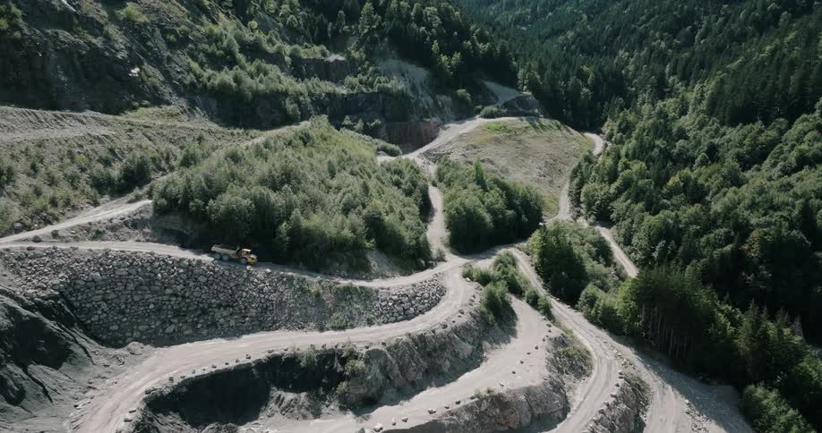 A dump truck drives downhill