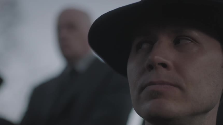 A man wearing a hat looks to the side