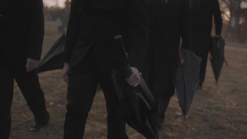 A group of people carrying umbrellas is walking