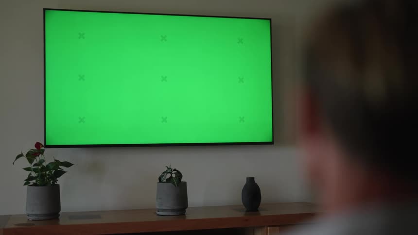 A person is sitting and watching television in their room