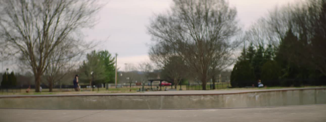 Topless man with jeans rollar skates in skatepark