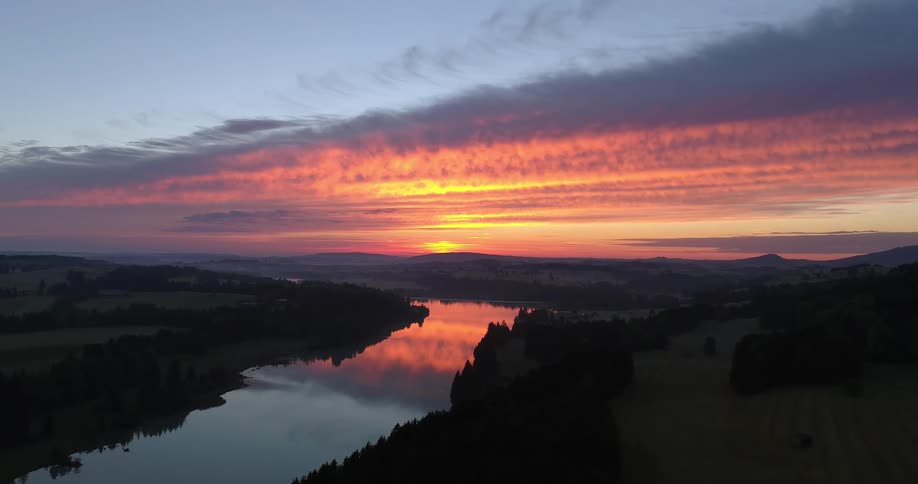 An aerial view of a reflective river in nature at sunset