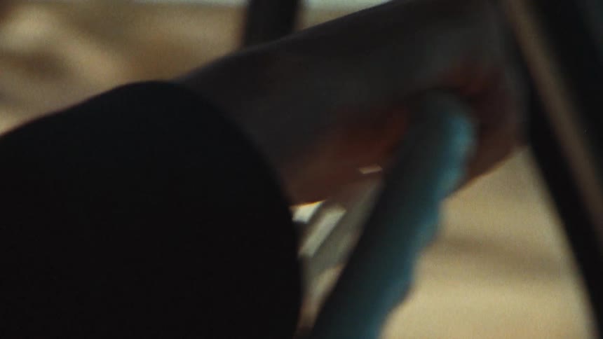 An up close of a persons hand on a steering wheel driving