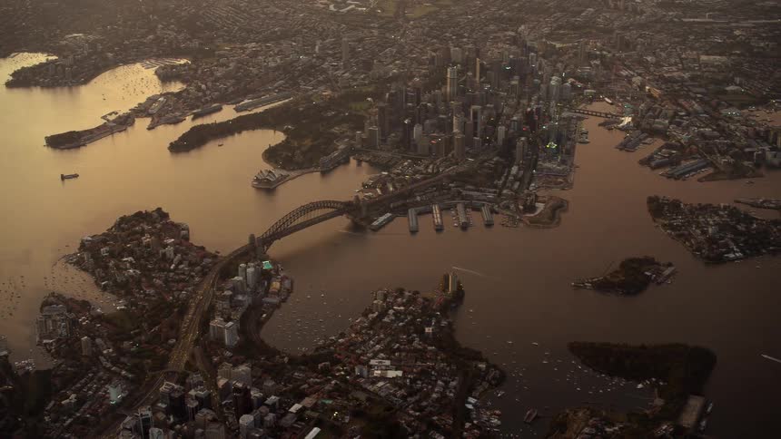 An aerial of a large city among a water reservoir with a bridge going over it