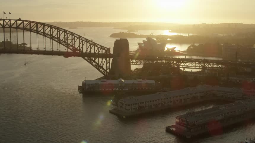 Aerial view of sydney harbor and port jackson bridge at sunrise with sun flair