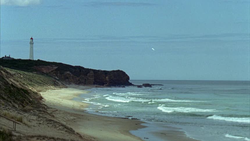 A narrow sandy beach during the day