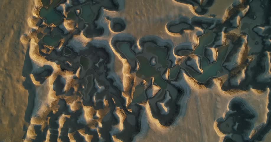 Top down aerial view of small interconnected lakes on the desert at evening
