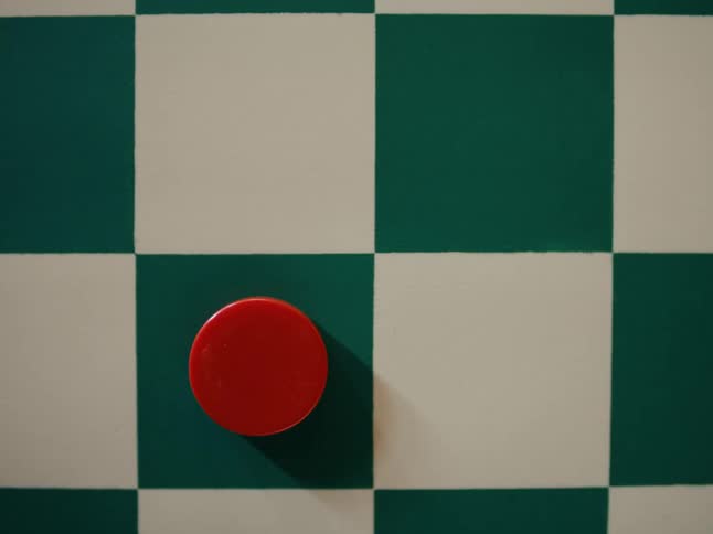 Red checker being placed on green square of checkerboard