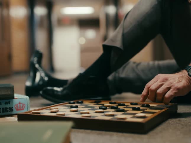 A man plays checkers in the hallway