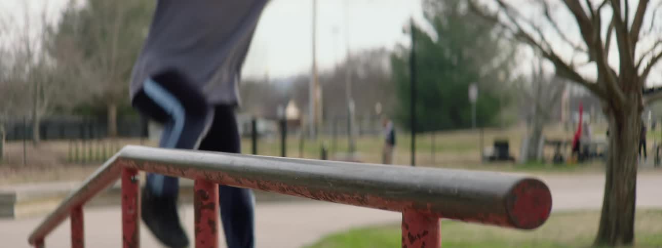 A man on roller blades jumps up and skids on a railing