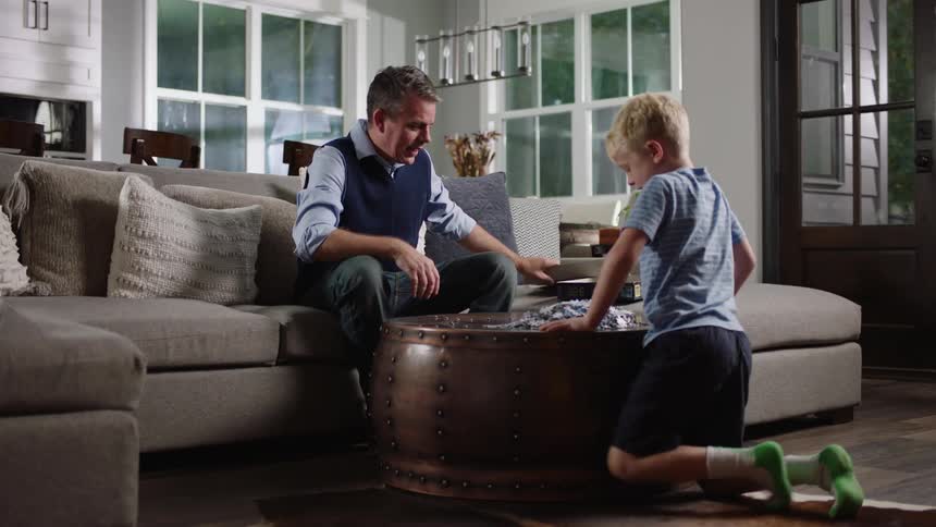 Father and son getting ready to build a puzzle on round coffee table