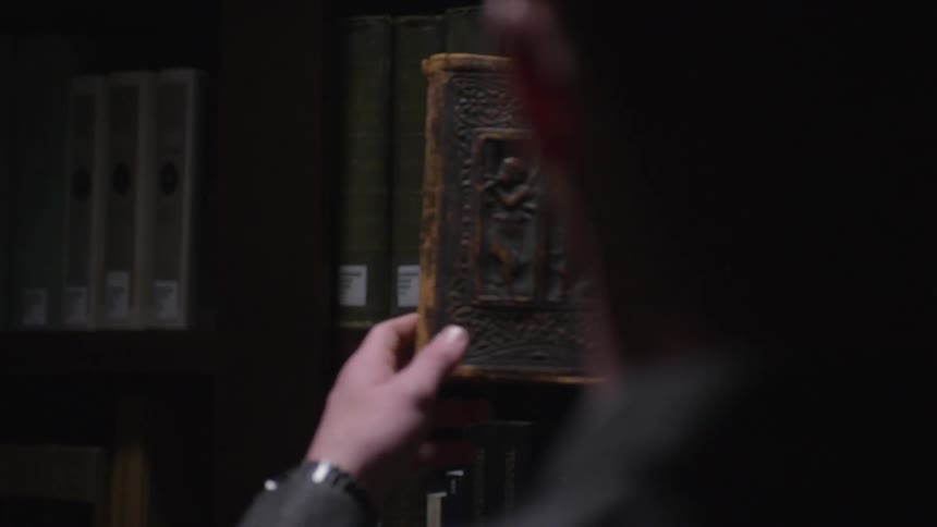 A person removes a book from the shelf