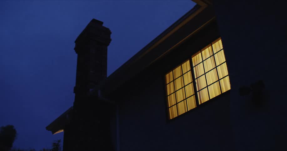 Floodlights attached to the wall of a house turning on and off at night