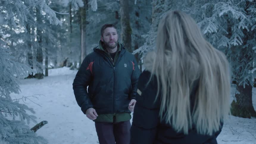A man walks over to a woman in the snow