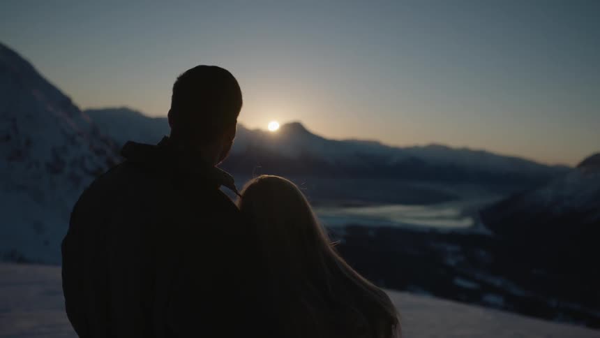 A couple embrace as the sun rises