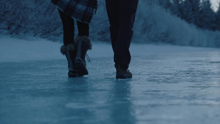 Two people walk over ice