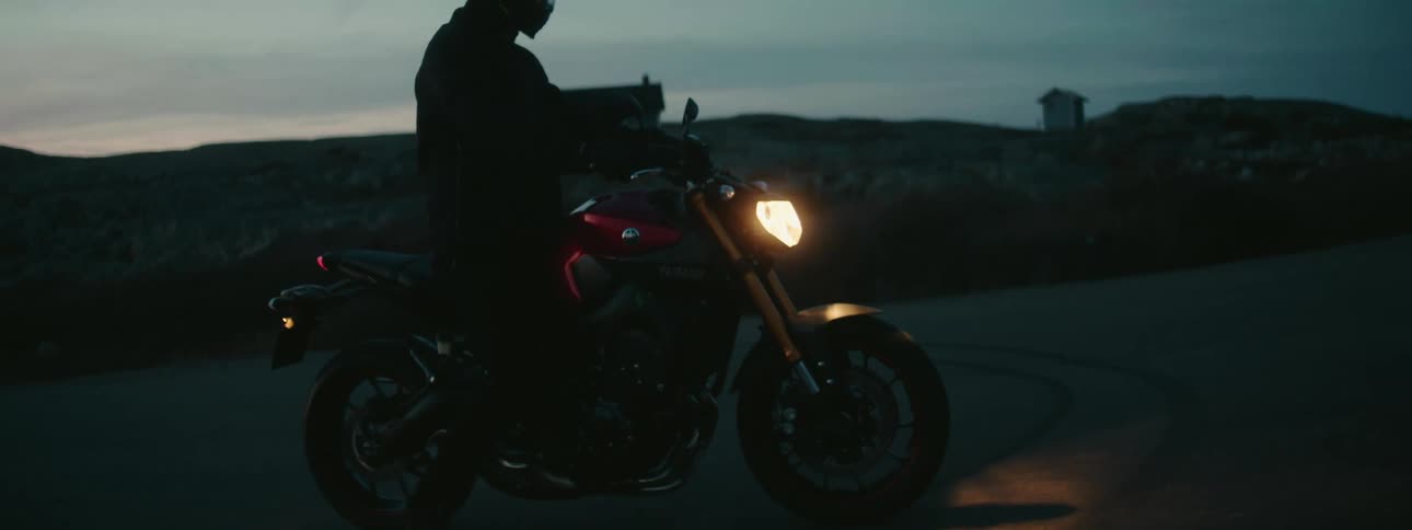 A man is riding a motorcycle during the sun set
