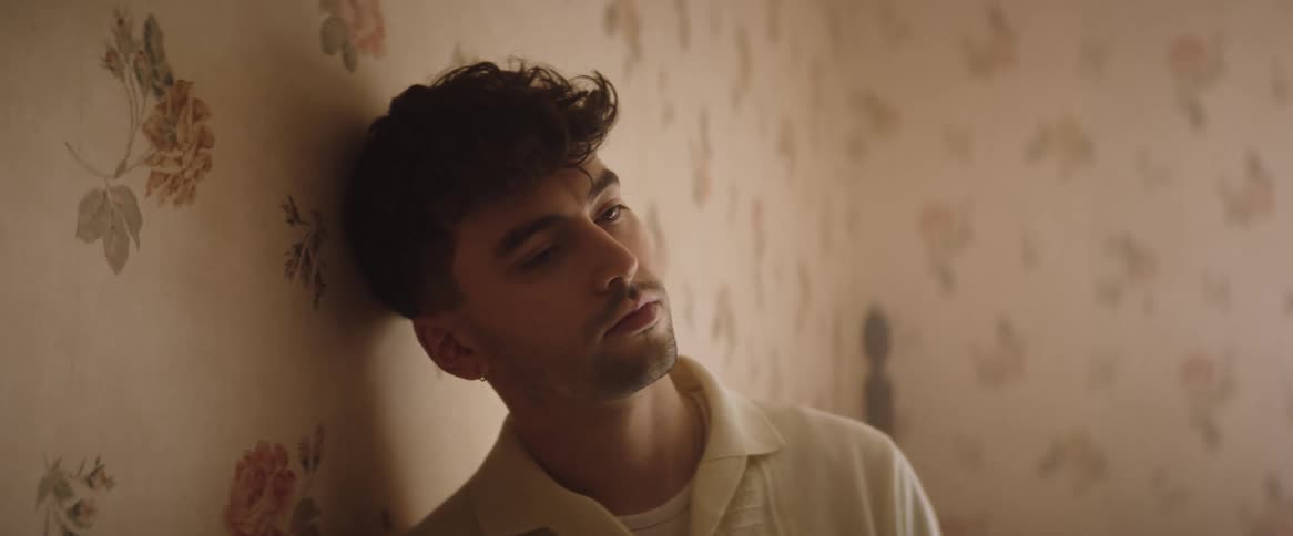 A man is leaning against the wall