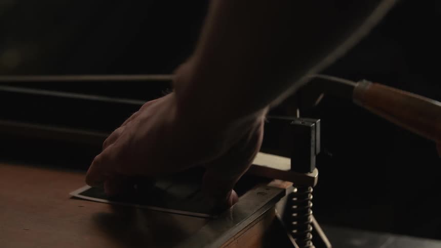 A person using a paper cutter cutting a picture