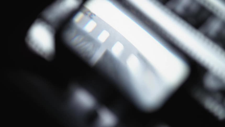 Close-up of film reeling through negatives, pictures, analog photography, darkroom mood