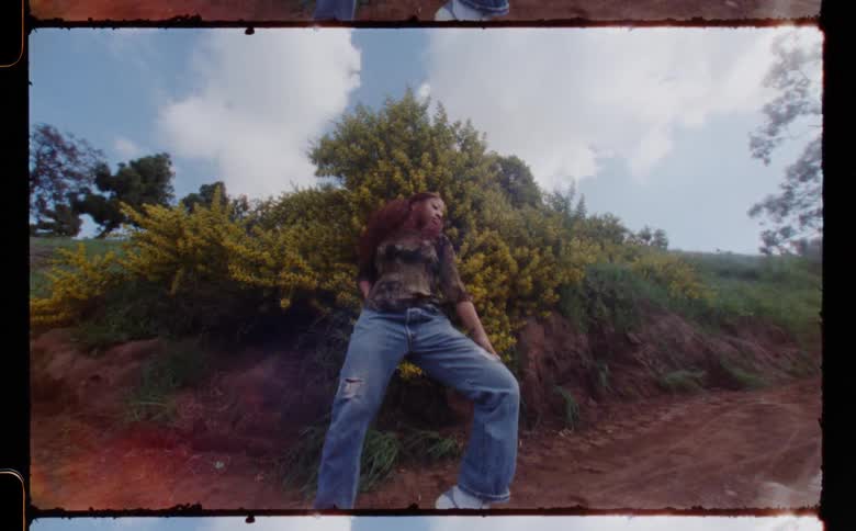A woman dancing and moving abruptly outdoors